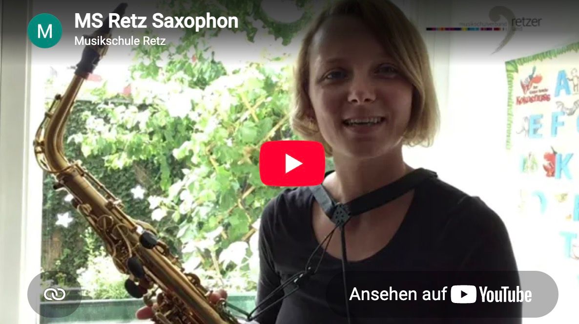 Kerstin Juritsch lächelt mit ihrem Saxophon vor einem Fenster in der Musikschule Retz